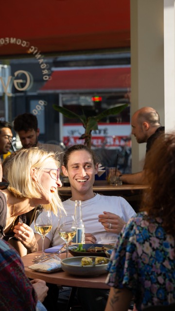 Je ziet iemand lachend op het terras