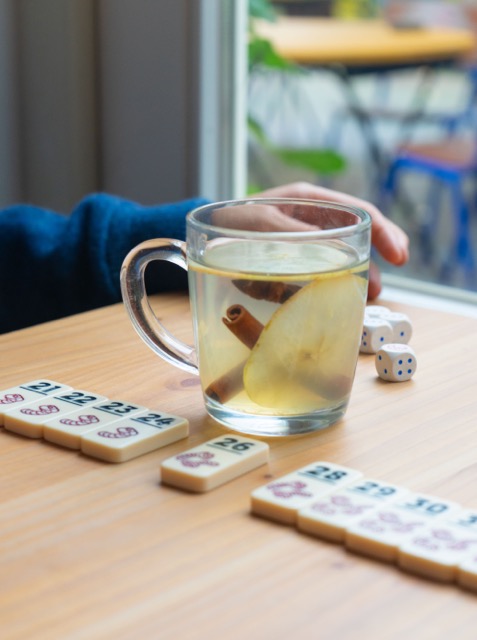 Je ziet een hand dat een glas vasthoudt en het spel regenwormen erbij