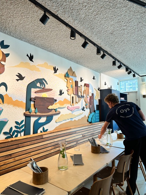 Iemand dekt een lange tafel voor een groep in